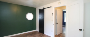 an empty room with green walls and wood floors