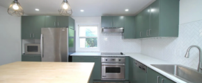 a kitchen with green cabinets and stainless steel appliances