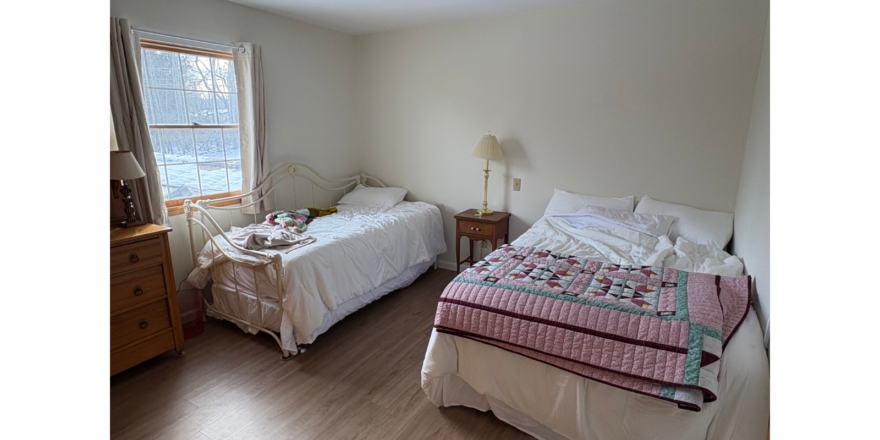 a bedroom with two beds and a dresser