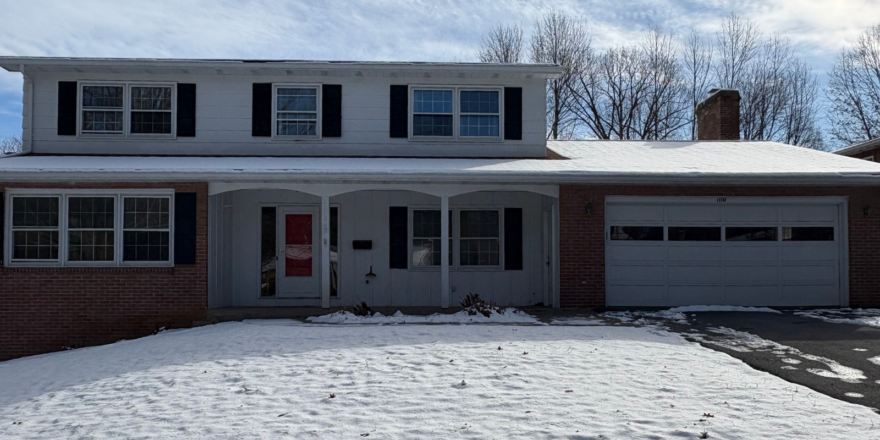 a house with snow on the ground in front of it
